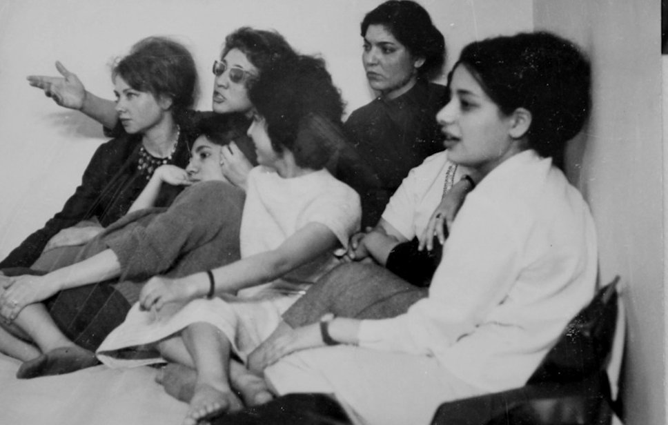 Un groupe de femmes assises, discutant et écoutant attentivement, visages concentrés.