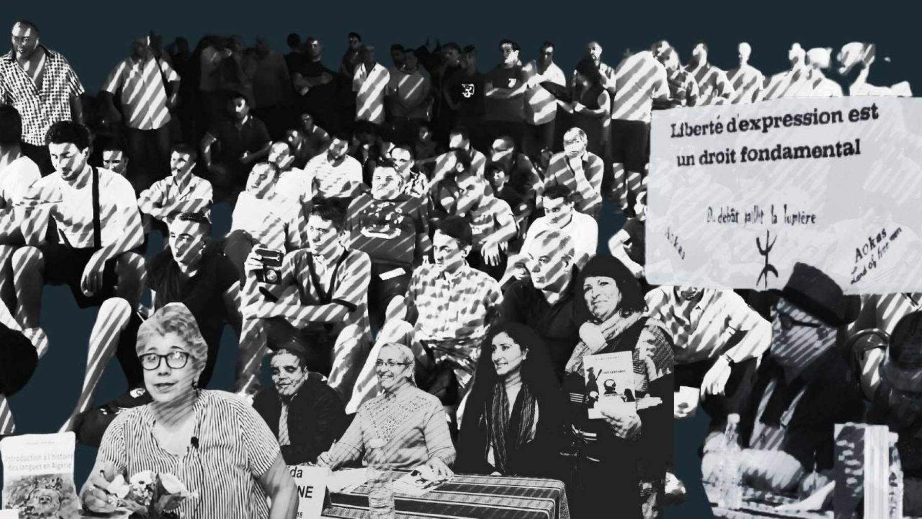 A diverse crowd of people sits in protest, holding signs advocating for freedom of expression.