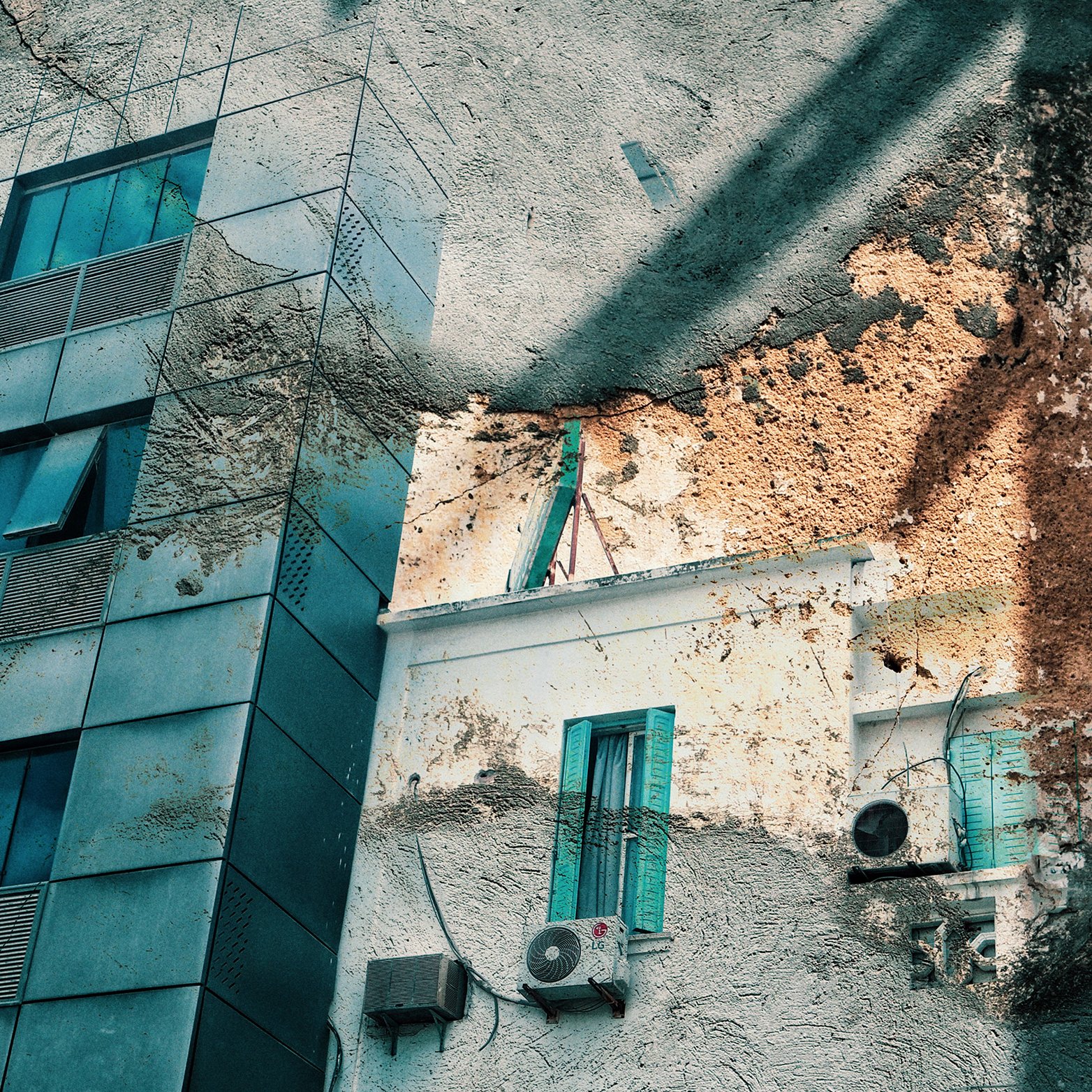 La imagen muestra la fachada de un edificio moderno de varios pisos, con ventanas de cristal y estructura metálica. Al lado, hay una pared de una construcción más antigua, que presenta desconchones y una textura envejecida. Se pueden ver persianas de color azul en algunas ventanas y un aire acondicionado montado en la pared. La mezcla de elementos arquitectónicos modernos y antiguos crea un contraste visual interesante, resaltando la historia y evolución del entorno urbano.