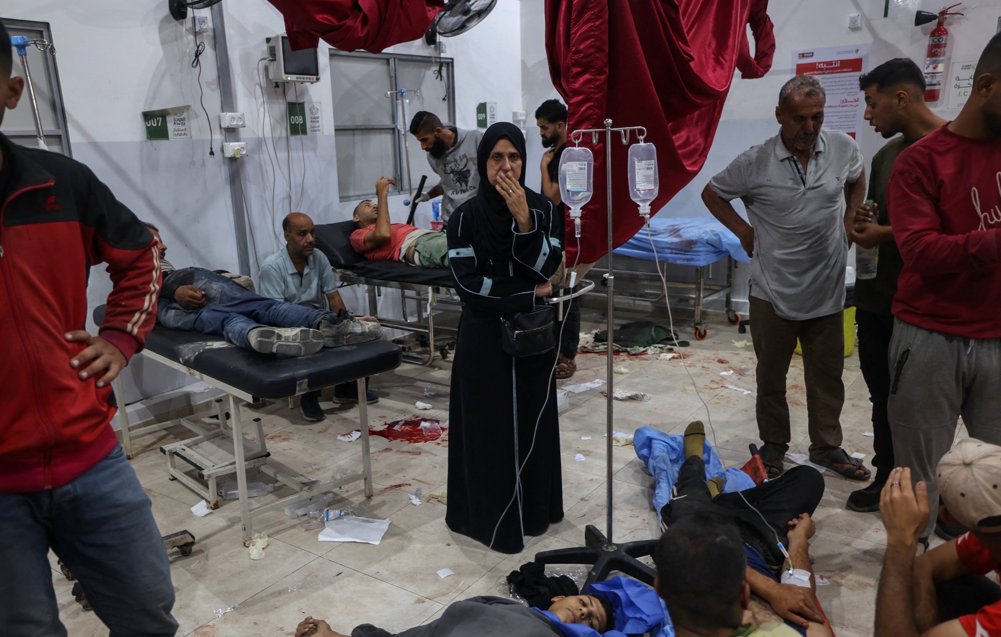 Une salle d'hôpital chaotique avec des blessés et des soignants.