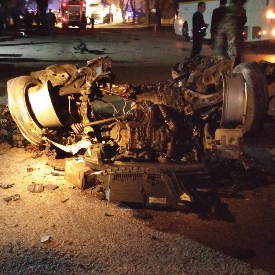 تظهر الصورة حادث سير خطير، حيث تكون السيارة مقلوبة على جانبها، وتبدو الأضرار كبيرة. يمكن رؤية أجزاء من السيارة مألوفة مثل العجلات والمكونات الداخلية، مع تشوهات واضحة نتيجة الاصطدام. الإضاءة خافتة، مما يدل على أن الحادث قد وقع في الليل. يبدو أن هناك أشخاصًا في الخلفية، ربما من فرق الطوارئ أو المتفرجين. الصورة تنقل إحساسًا بالكارثة والخطورة.