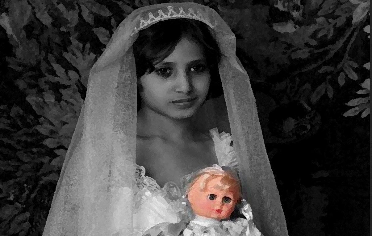 در این تصویر، دختری با لباس عروسی سفید دیده می‌شود. او یک تور سفید بر سر دارد و در دستانش یک عروسک حدوداً صورتی‌رنگ را نگه داشته است. چهره‌اش حالتی ملایم دارد و به دوردست نگاه می‌کند. زمینه تصویر با نقوش گیاهی و تیره‌تری تزئین شده که توجه را به خود جلب می‌کند. این ترکیب رنگی و حال و هوا حس نوستالژیک و بی‌گناهی را منتقل می‌کند.