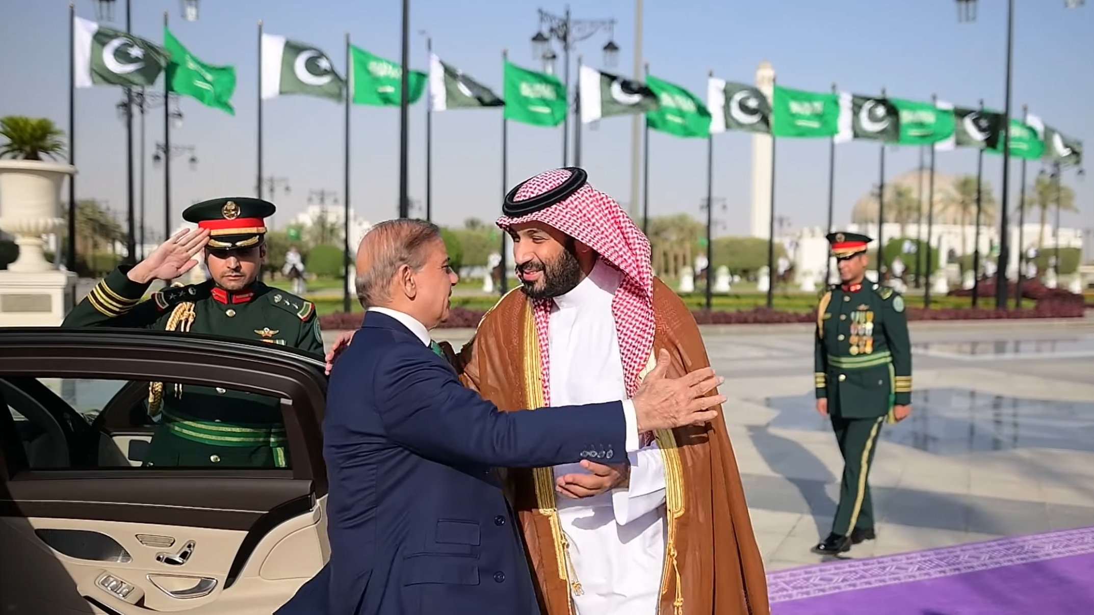 لقاء رسمي بين قائدين، مع أعلام وموظفين عسكريين في الخلفية.