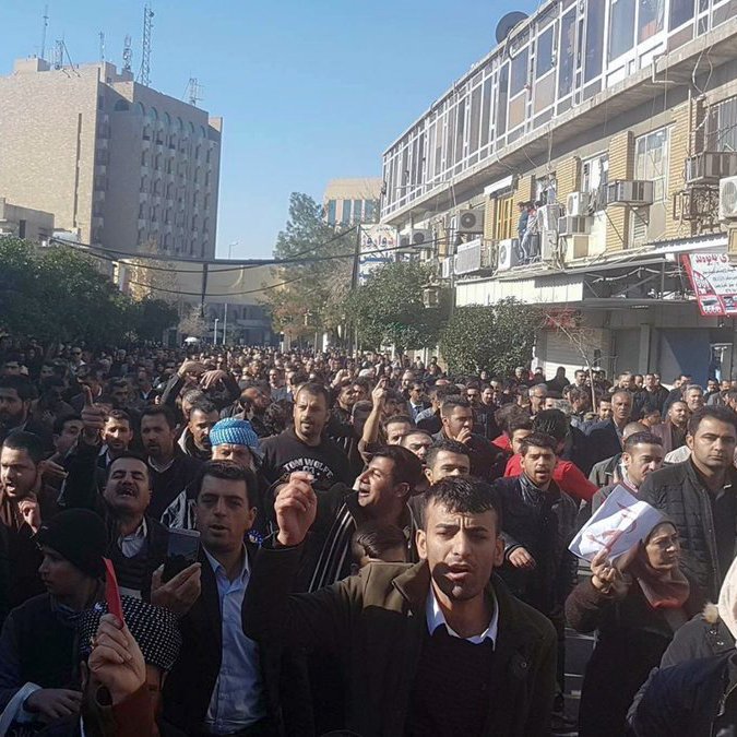 در این تصویر، جمعیتی بزرگ در یک خیابان شهری دیده می‌شود. افراد در حال راهپیمایی هستند و برخی از آن‌ها دست‌ها را بالا برده یا نمادهایی را در دست دارند. ساختمان‌ها و تابلوهای مغازه‌ها در اطراف قابل مشاهده‌اند، و به نظر می‌رسد که این تجمع به منظور ابراز نظر یا اعتراض صورت گرفته است. آسمان روشن بوده و در پس‌زمینه، سازه‌های بلند دیده می‌شوند. جو عمومی تصویر نشان‌دهنده حرکت و فعالیت جمعیت است.