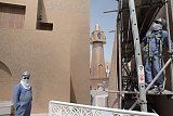 Operai che indossano una sciarpa per limitare gli effetti della luce e dell'aria torrida (32 gradi a marzo) in un cantiere nel «villaggio culturale» di Katara