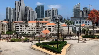 A cityscape featuring modern skyscrapers, residential buildings, and landscaped areas.