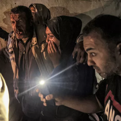 Un groupe de personnes dans une lumière tamisée, exprimant des émotions fortes.