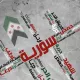 L'image présente un fond texturé avec des mots écrits en arabe qui semblent faire référence à la Syrie et à des thèmes liés à la liberté et à la résistance. On observe également un symbole, probablement représentant le drapeau syrien, qui est intégré dans la composition. Les mots sont disposés de manière dynamique, créant un effet visuel impactant. La palette de couleurs est principalement neutre, mettant en avant le texte en rouge.