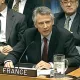 Homme en costume, sérieux, représentant la France lors d'une réunion officielle.
