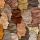 L'image représente une mosaïque de profils humains en silhouettes, créés à partir de papier froissé aux différentes nuances de couleurs de peau. Les teintes varient du beige clair au brun foncé, illustrant la diversité des origines humaines. La texture froissée ajoute une dimension tactile à l'œuvre, suggérant une approche artistique qui évoque à la fois l'unité et la diversité.