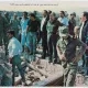 Un groupe d'hommes en uniforme et en civil, observant des débris.