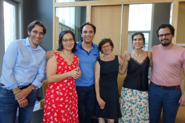 Un groupe de six personnes souriantes, habillées de façon décontractée, posent ensemble.