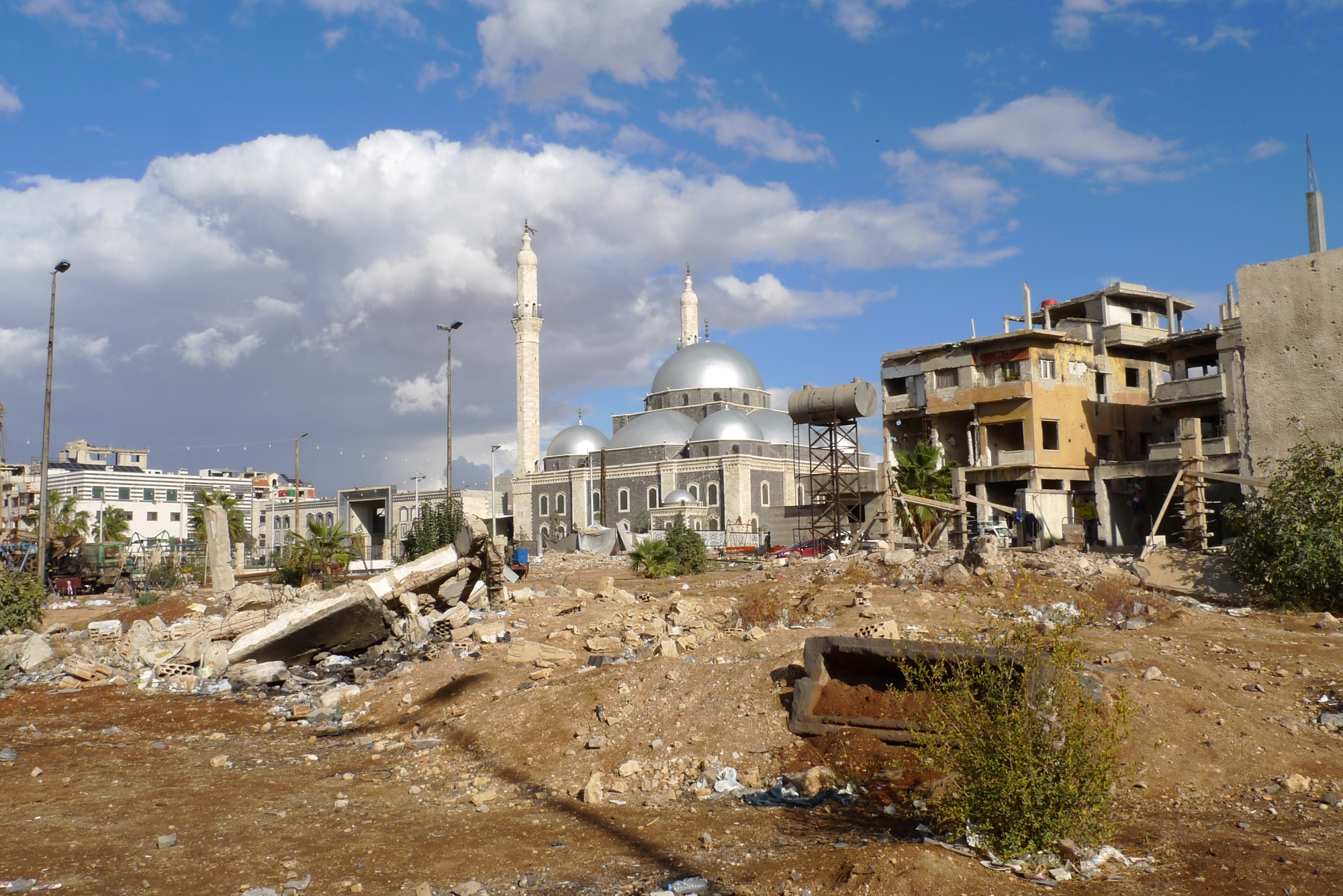 Un paysage contrasté avec une mosquée majestueuse et des ruines environnantes.