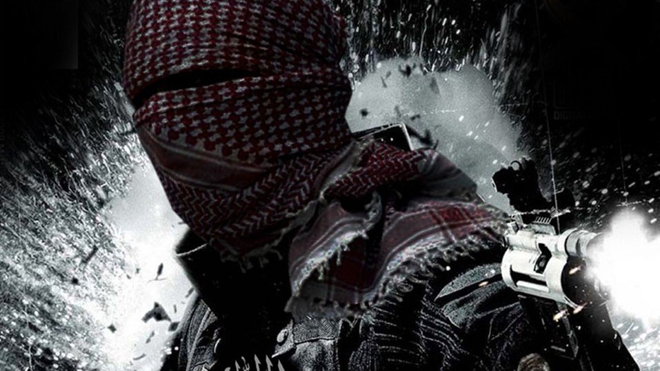 تظهر في الصورة شخصية ملثمة ترتدي غطاء رأس تقليدي، وتحمل أسلحة في يديها. الخلفية تبدو مشوشة وكأنها تعبر عن حالة من الفوضى أو الصراع. كما يظهر جزء من نص عربي في أسفل الصورة، يضيف طابعًا دراميًا للمشهد. تعكس الصورة أجواء من القوة والتوتر.