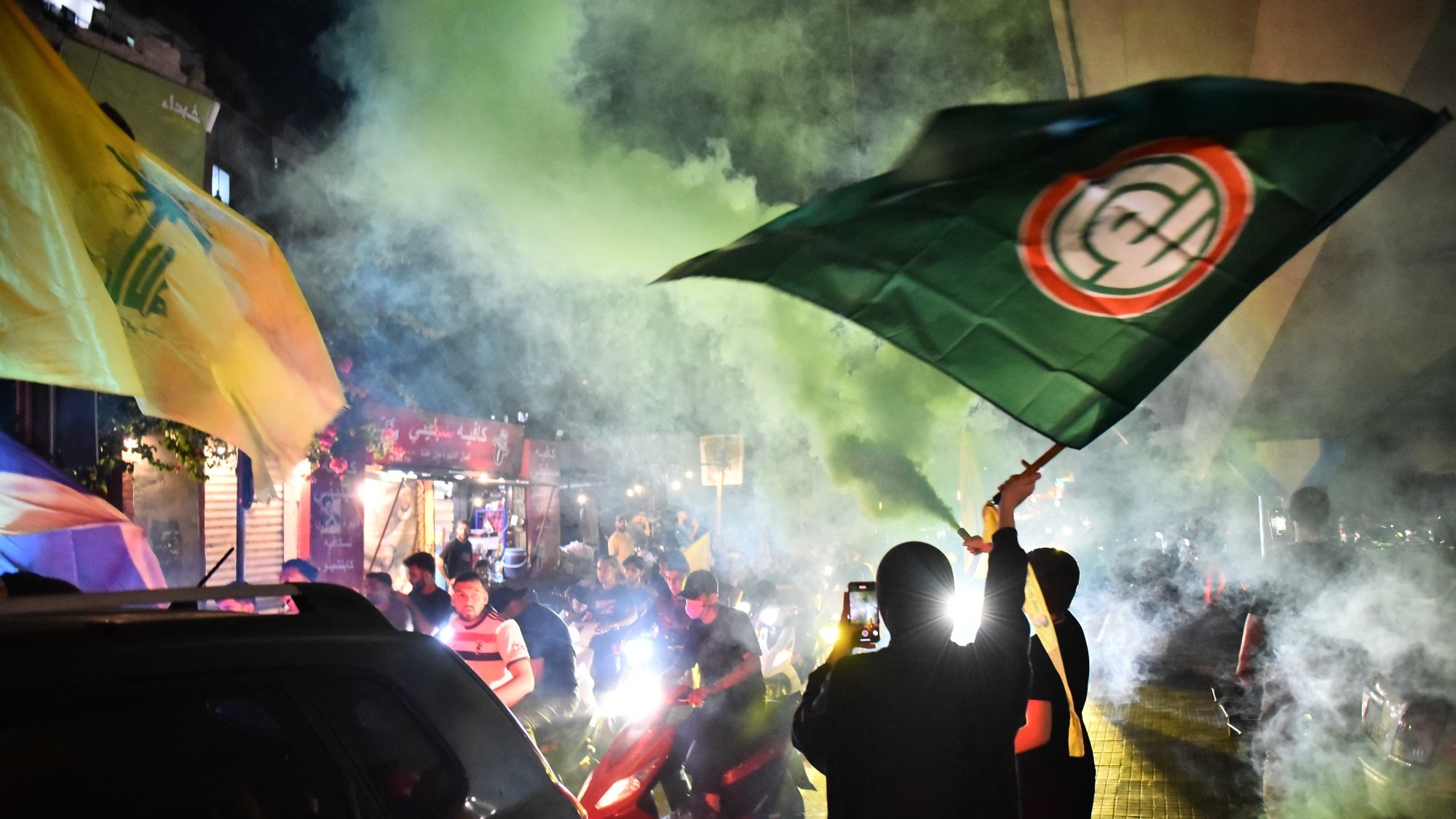 مظاهرة حيوية مليئة بالأعلام والدخان الملون، مع أجواء من الحماس والضجيج.