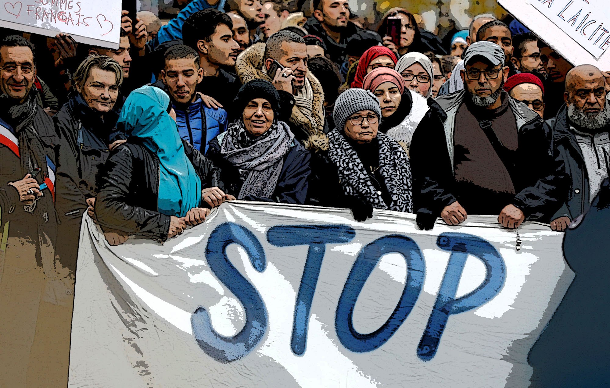 The image depicts a large group of people gathered together, holding a banner that prominently features the word "STOP." The individuals are dressed in various winter attire, including scarves and jackets, suggesting it may be cold. Some in the crowd appear to be wearing traditional clothing or head coverings. The atmosphere seems to convey a sense of unity and purpose, likely indicating a collective protest or demonstration. There are additional signs raised around the crowd, emphasizing their message.