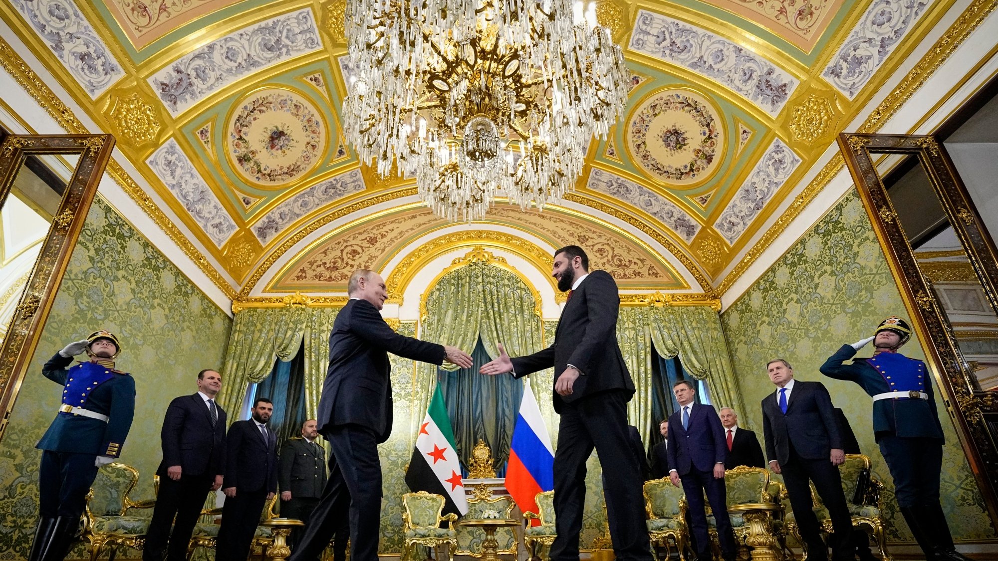 A formal meeting in an ornate room, with leaders shaking hands and military personnel in uniform.