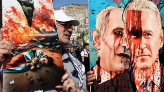 La imagen muestra a un manifestante sosteniendo dos carteles. En el cartel de la izquierda, hay una ilustración impactante que representa un ambiente devastado, con un niño tirado en el suelo, y elementos que sugieren destrucción y sufrimiento. El cartel de la derecha presenta retratos de dos figuras, probablemente con un contexto político, mostrando rostros con sangre, lo que sugiere un mensaje fuerte y crítico sobre la violencia o el conflicto. Ambos carteles reflejan una expresión poderosa de protesta.