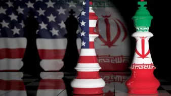 تصویر نشاندهنده دو مهره شطرنج است که به نمادهای ملی ایالات متحده و ایران تزئین شدهاند. مهره سفید به پرچم ایالات متحده و مهره قرمز به پرچم ایران منقش شده است. پسزمینه تصویر تاریک و مرموز است و حس رقابت و تضاد بین دو کشور را منتقل میکند. زمین شطرنج نیز با الگوی خاصی به تصویر اضافه شده که به فضای بازی شطرنج اشاره دارد.