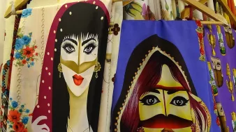 این تصویر شامل تصاویری از دو زن است که در طرحهای رنگارنگ و با جزئیات جذاب روی پارچهها نقاشی شدهاند. هر دو زن دارای ویژگیهای خاصی هستند، از جمله حالتهای صورت و پوشش متفاوت. طراحیها شامل رنگهای زنده و الگوهای متنوعی هستند که توجه را جلب میکنند. یکی از زنان به رنگهای تیره و دیگری به رنگهای روشنتر نمایش داده شده است که کنارههای شال یا دستمالی روی سر دارند. این نوع طراحیها معمولا در فرهنگهای مختلف به منظور نمایش زیبایی و سنتها استفاده میشود.