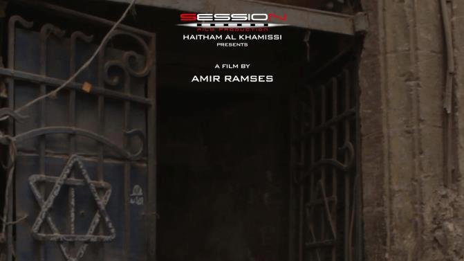 L'image présente une porte ancienne avec des éléments architecturaux caractéristiques. Au-dessus de la porte, on distingue une étoile de David, symbolisant une connexion à la culture juive. Le titre "Jews Egypt" est inscrit en français et en arabe, indiquant qu'il s'agit d'un film. En bas de l'image, on trouve une liste de noms associés à la production, suggérant une œuvre cinématographique portant sur l'histoire ou la communauté juive en Égypte. L'atmosphère est mélancolique, reflétant probablement des thèmes de mémoire et d'identité.