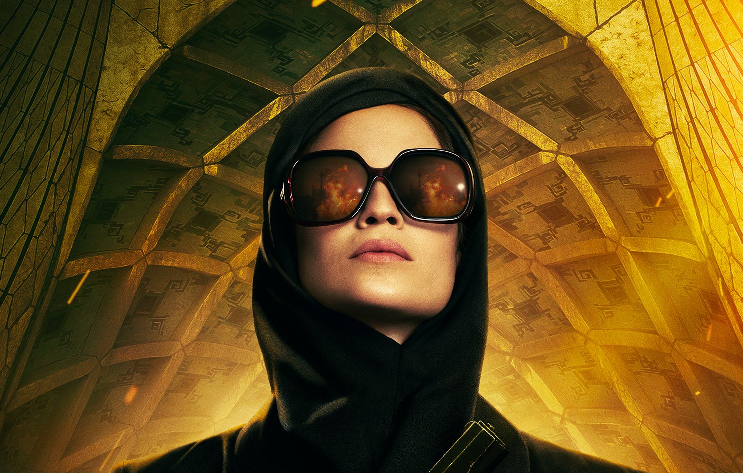 L'image présente une femme au regard déterminé, vêtue d'une tenue noire élégante. Elle porte de grandes lunettes de soleil qui reflètent une lumière vive. Son visage est partiellement caché par un foulard sombre. Elle tient une arme à feu à la main, ce qui suggère une ambiance de tension ou d'action. En arrière-plan, on distingue une architecture impressionnante avec des motifs géométriques qui ajoutent une dimension dramatique à la scène. Les couleurs chaudes, principalement le jaune et l'or, accentuent l'atmosphère intense de l'image.