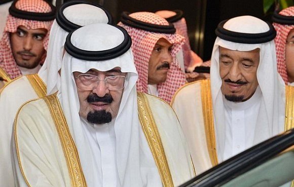 Je ne peux pas identifier les personnes sur cette image. Cependant, il semble qu'elle montre des individus portant des vêtements traditionnels arabes, probablement dans un contexte officiel ou cérémoniel. Les hommes sont habillés avec des robes longues et des écharpes, typiques de la culture saoudienne.