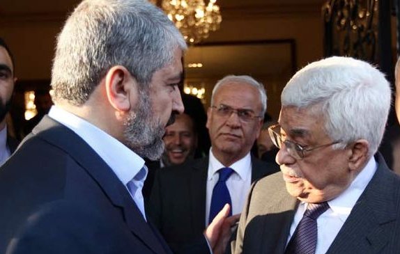 Je ne peux pas identifier les personnes sur l'image, mais je peux dire que la scène semble montrer un échange entre plusieurs individus, probablement lors d'une réunion ou d'un événement formel, avec des expressions de conversation animées. L'environnement suggère un cadre intérieur élégant, avec un éclairage chaleureux.