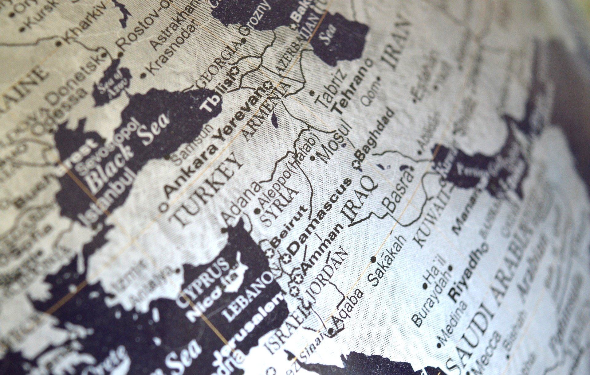 L'image montre une carte géographique en noir et blanc de la région du Moyen-Orient. On y voit des pays tels que la Turquie, l'Iran, l'Irak, la Syrie et l'Arabie Saoudite, ainsi que des villes importantes comme Bagdad et Bassora. Les noms des pays et des villes sont clairement inscrits, offrant une perspective sur la géographie de cette zone. La carte semble ancienne, ce qui lui donne un aspect vintage.