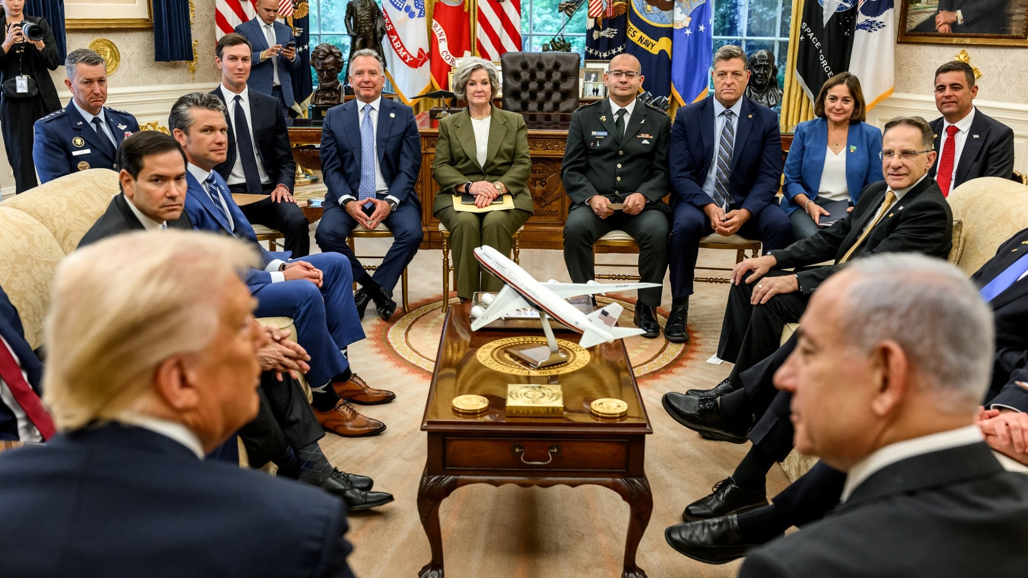 Des responsables politiques discutent autour d'une table dans un bureau officiel.