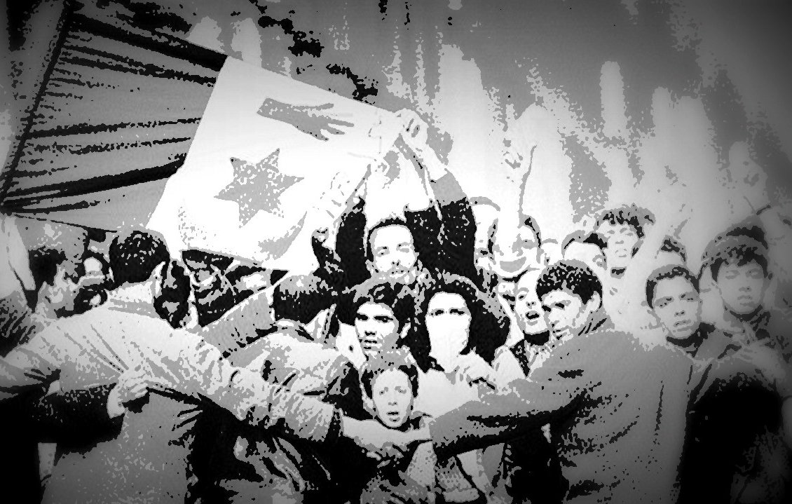 L'image montre une scène de rassemblement populaire où des manifestants brandissent une grande bannière ou un drapeau. Les participants semblent célébrer ou exprimer des revendications, et il y a une forte énergie collective. Certains visages sont visibles, reflétant diverses émotions, allant de la détermination à la joie. La composition en noir et blanc crée une atmosphère nostalgique et dramatique, soulignant l'importance historique de cet événement.