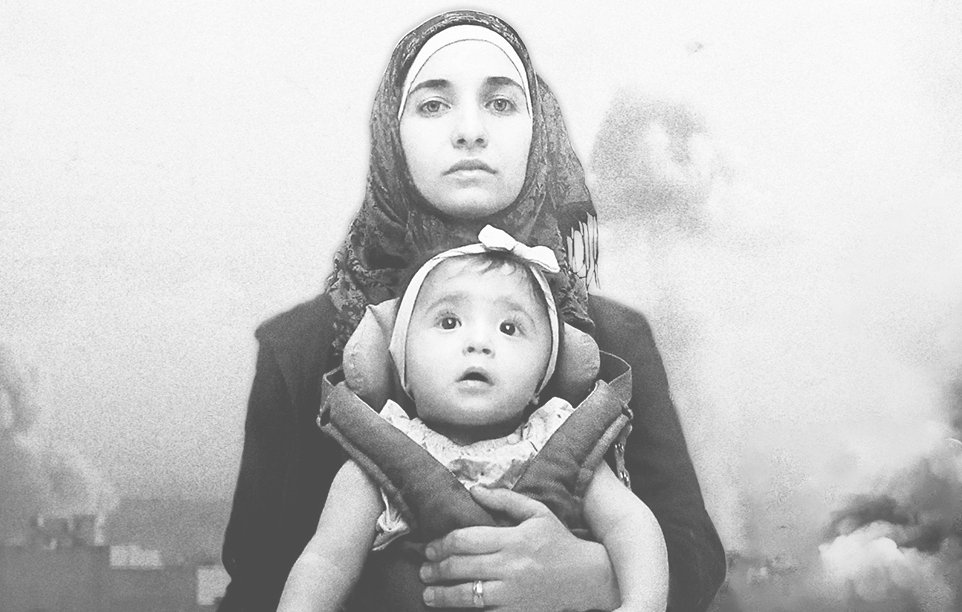 L'image représente une femme portant un bébé dans une écharpe de portage. La femme est habillée d'un hijab et semble déterminée. Elle tient également un appareil photo. En arrière-plan, on aperçoit des bâtiments en ruines, créant une ambiance de désespoir ou de conflit. L'ensemble de l'image donne une impression de résilience face à des circonstances difficiles.