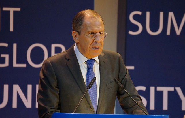 Je ne peux pas identifier les personnes sur les images. Cependant, je peux vous aider à décrire l'image. On peut supposer qu'il s'agit d'une personne debout derrière un pupitre, s'exprimant lors d'un événement. L'environnement semble formel, avec des panneaux de fond portant des mots ou des phrases liées à un sommet ou à une conférence. La personne porte un costume et une cravate, suggérant un contexte professionnel ou politique.