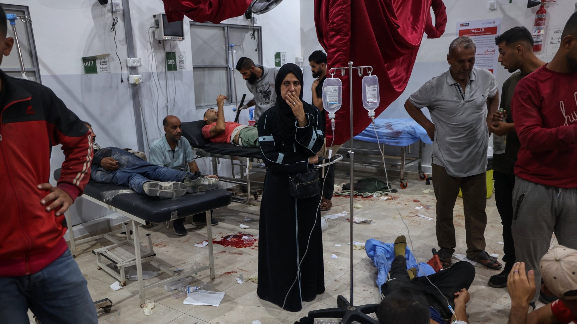 Une salle d'hôpital chaotique avec des blessés et des soignants.