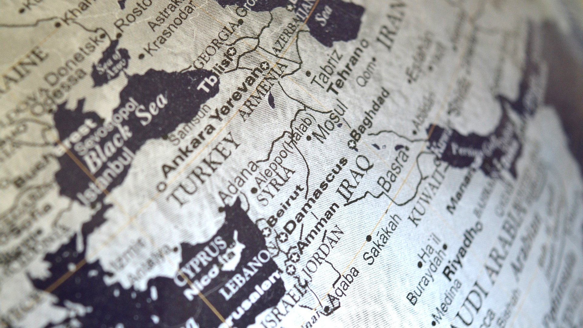 L'image montre une carte géographique en noir et blanc de la région du Moyen-Orient. On y voit des pays tels que la Turquie, l'Iran, l'Irak, la Syrie et l'Arabie Saoudite, ainsi que des villes importantes comme Bagdad et Bassora. Les noms des pays et des villes sont clairement inscrits, offrant une perspective sur la géographie de cette zone. La carte semble ancienne, ce qui lui donne un aspect vintage.