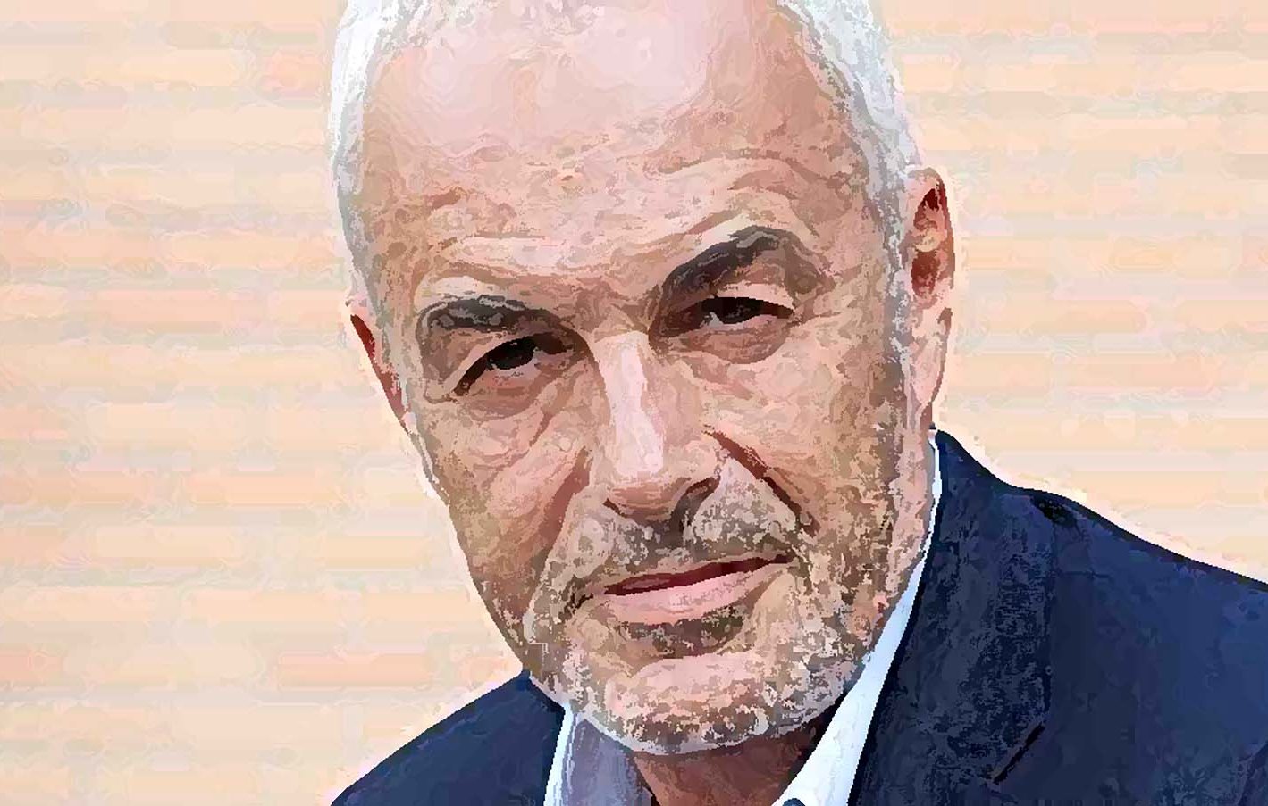 Je ne sais pas qui est cette personne, mais l'image présente un homme avec des cheveux gris et une barbe légèrement poivrée. Il a l'air sérieux et regarde directement l'objectif. Il porte un blazer sombre sur une chemise, et le fond semble aux teintes claires.