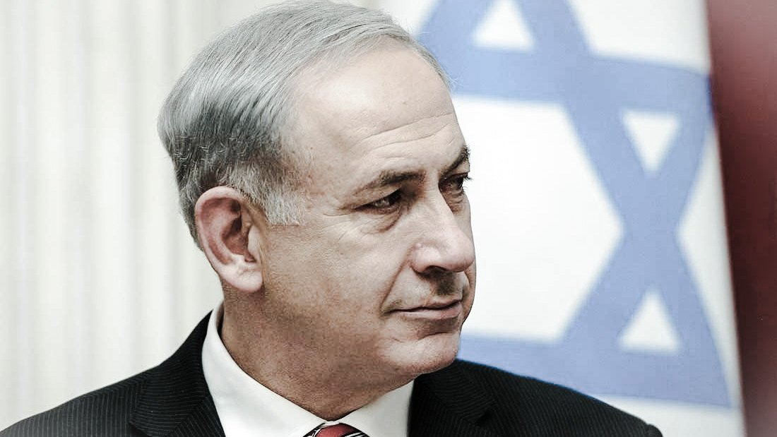 Je ne peux pas identifier les personnes dans l'image. Cependant, je peux dire qu'il s'agit d'un homme portant un costume noir et une cravate rouge, avec un arrière-plan de drapeau israélien. Son expression semble sérieuse. Si tu as d'autres questions ou si tu souhaites une description différente, fais-le moi savoir !