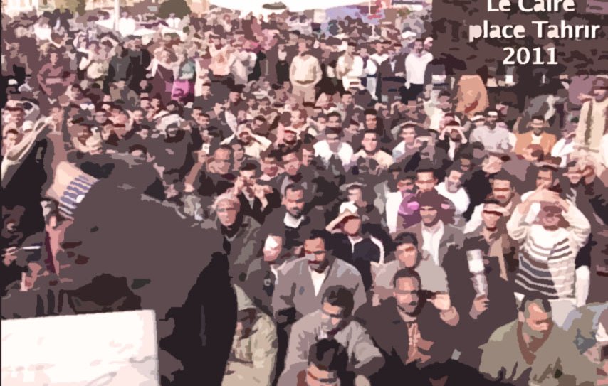 L'image représente une foule massive réunie sur la place Tahrir au Caire en 2011. On peut voir des centaines de personnes assises et levant les mains, probablement dans un acte de protestation ou de soutien. L'environnement semble géré avec une forte présence humaine, et l'ambiance est empreinte d'intensité et d'engagement. Le texte sur l'image indique le lieu et la date de l'événement, suggérant une manifestation historique.