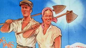 L'image présente un couple de travailleurs agricoles, un homme et une femme, souriant et portant des outils de travail. Ils se tiennent debout dans un paysage de champ, avec des palmiers en arrière-plan. L'homme est vêtue d'une chemise blanche et d'un pantalon court, tandis que la femme porte également une chemise blanche et un foulard autour de la tête. La lumière du soleil éclaire la scène, créant une atmosphère positive et dynamique, évoquant un sens de la coopération et de l'espoir. En arrière-plan, on peut apercevoir des chameaux et un bâtiment, ajoutant une touche de contexte au cadre rural.