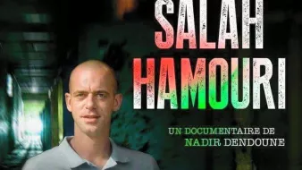 L'image présente un homme nommé Salah Hamouri, qui est au centre d'un documentaire réalisé par Nadir Dendoune. On le voit dans un environnement sombre, peut-être un couloir ou un espace industriel. Le texte indique qu'il s'agit de l'affaire de Salah Hamouri et pose la question de pourquoi un Franco-Palestinien a été emprisonné dans l'indifférence générale. L'atmosphère générale évoque un sentiment de gravité et d'urgence concernant son histoire.