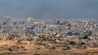 Terrain dévasté avec des bâtiments en ruines et des machines de chantier.