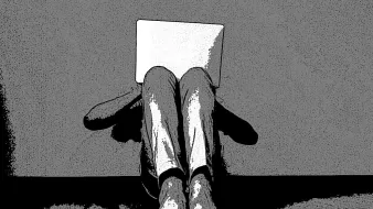 L'image montre une personne assise contre un mur, les jambes repliées et les pieds nus visibles. Elle tient un ordinateur portable ouvert devant elle, cachant probablement son visage. Le contraste noir et blanc donne un aspect artistique et minimaliste à la scène. Le fond est simple et met en avant la posture de la personne, ajoutant une impression de solitude ou d'introspection.