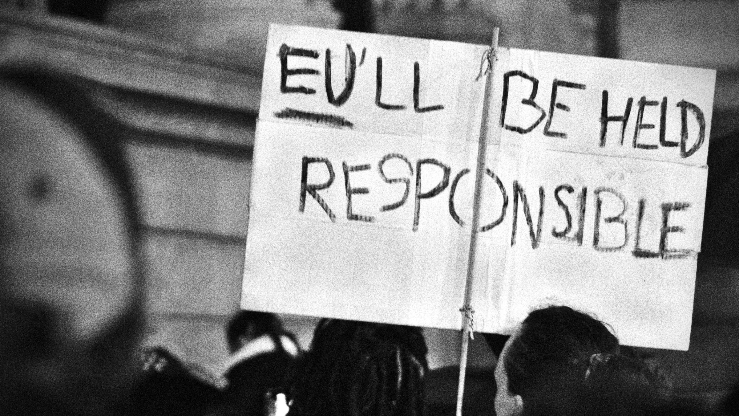 Un cartello con la scritta "You'll be held responsible" in un contesto di protesta.