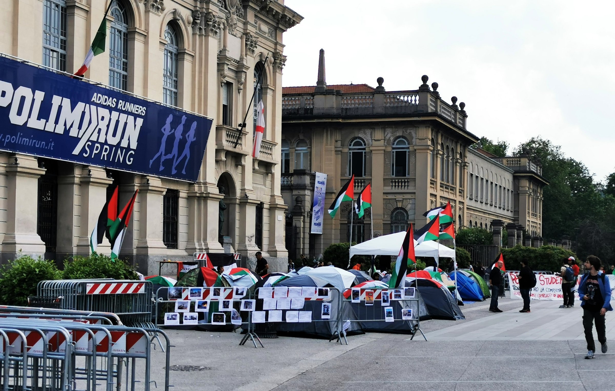 Un campo con tende, bandiere palestinesi e cartelli di protesta.