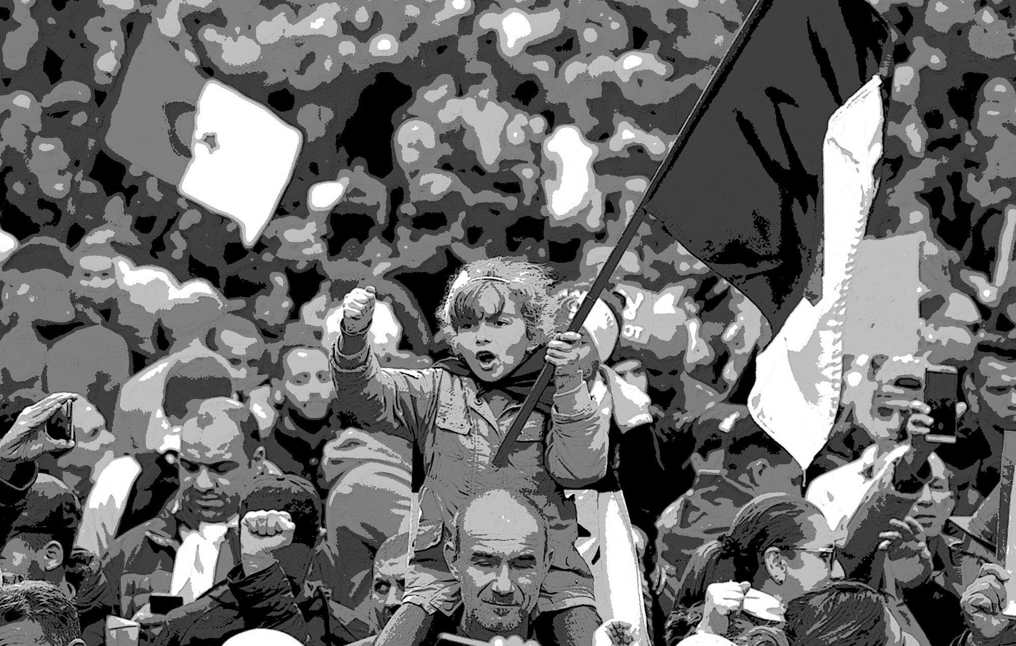 L'immagine ritrae una folla di persone in un contesto di protesta o manifestazione. Al centro, una bambina è sollevata su una spalla e tiene in mano una bandiera, esprimendo un gesto di forza con il pugno chiuso. Gli adulti intorno a lei, alcuni con espressioni determinate, sembrano unirsi a un messaggio comune. La scena è caratterizzata da un forte senso di coinvolgimento e determinazione. L'atmosfera è intensa, con varie bandiere e manifestanti tutti insieme.
