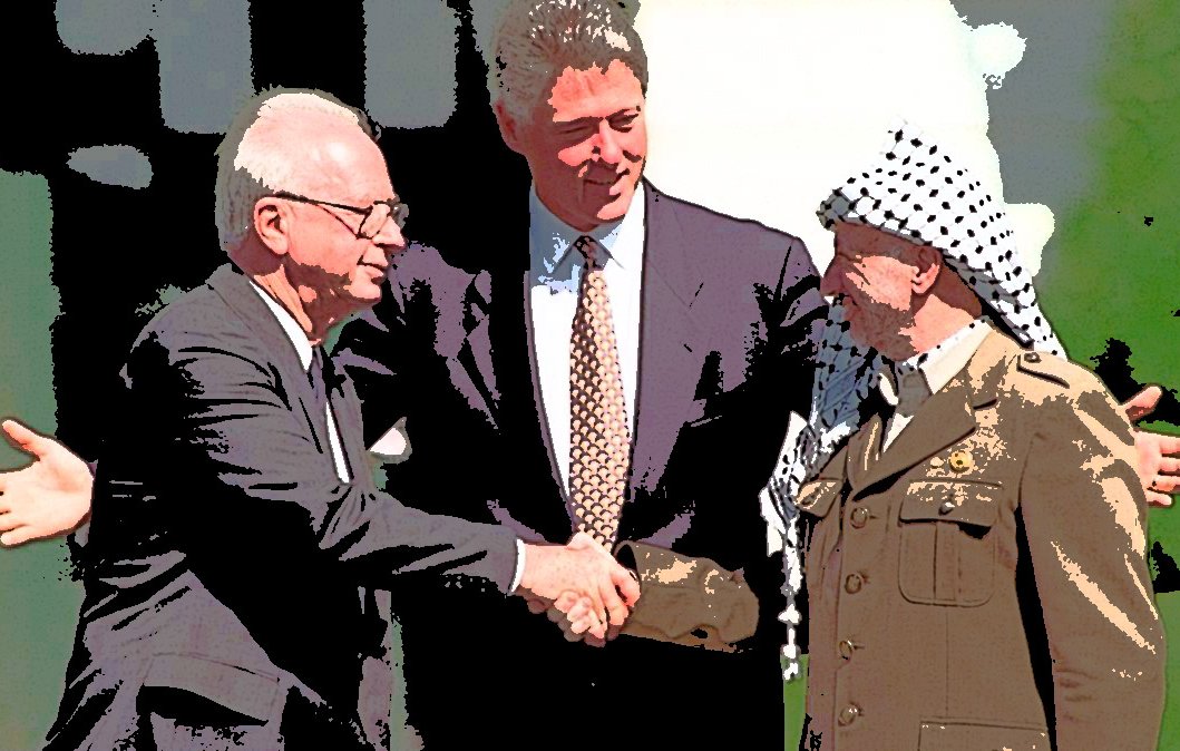 L'immagine mostra tre figure principali in un contesto storico. Al centro, un uomo con un vestito scuro e una cravatta sorride mentre stringe la mano a due uomini. Sulla sinistra, un uomo con occhiali e un abito formale sembra accogliere l'altra persona, che indossa un'uniforme militare con un copricapo caratteristico. L'atmosfera trasmette un senso di intesa e speranza, sottolineato dall'abbraccio e dal sorriso dei presenti, suggerendo un'importante occasione di dialogo o accordo.