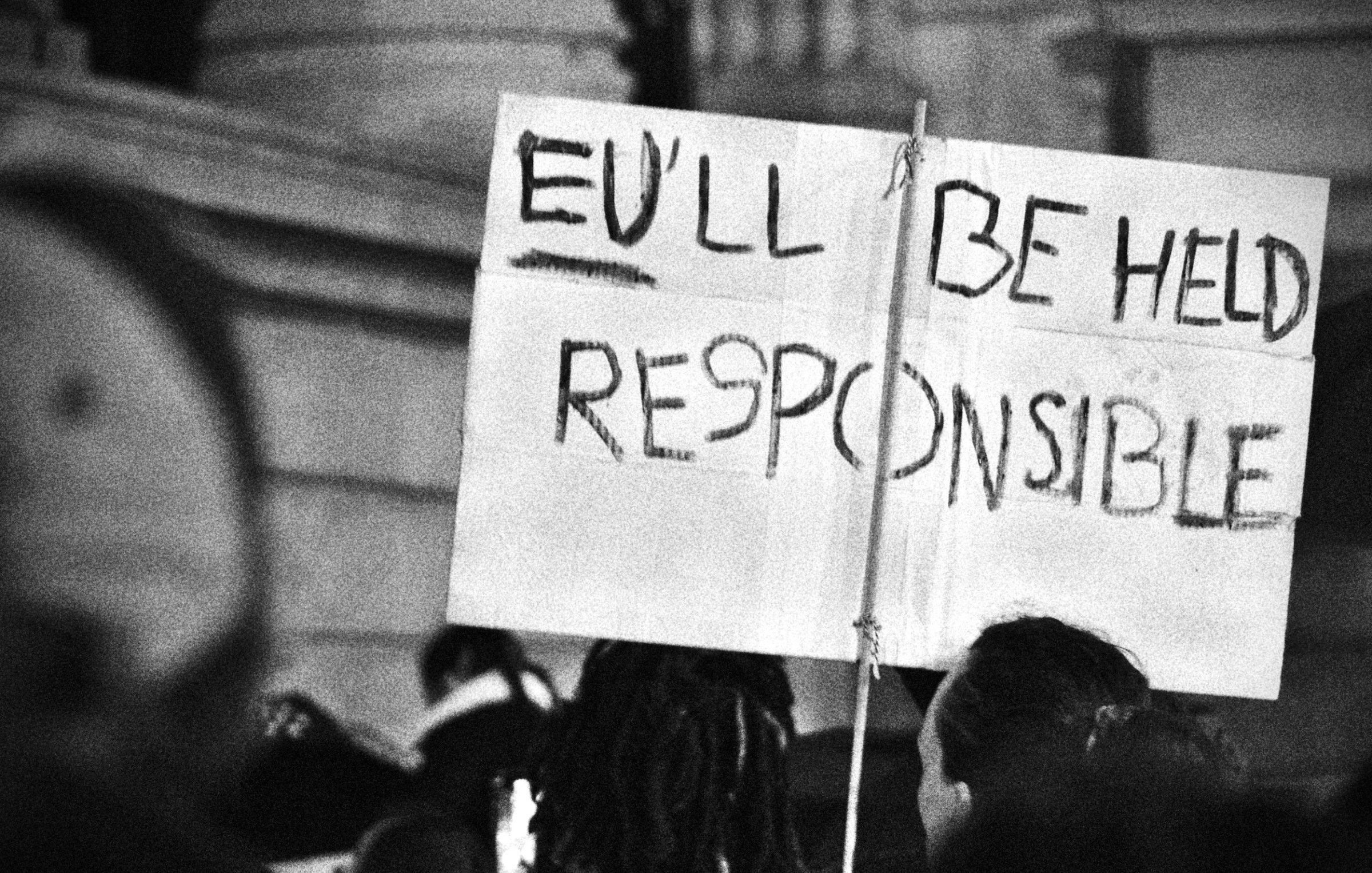 Un cartello con la scritta "You'll be held responsible" in un contesto di protesta.