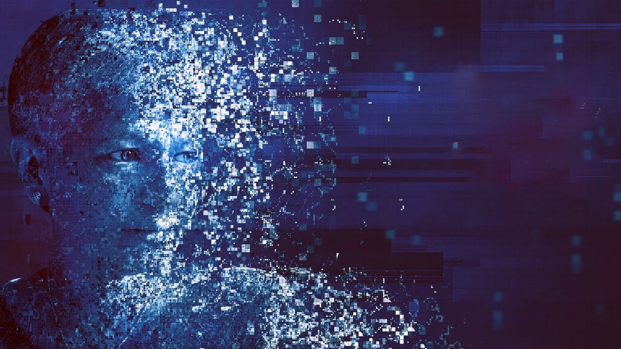 L'image représente une figure humaine stylisée qui semble se désintégrer ou se fragmenter en une multitude de petits pixels. Les couleurs dominantes sont des nuances de bleu et de violet, créant une ambiance numérique et futuriste. Le visage est partiellement visible, entouré d'effets visuels qui renforcent l'idée de décomposition ou de virtualisation. Cette œuvre évoque des thèmes liés à la technologie, l'identité et la transformation numérique.