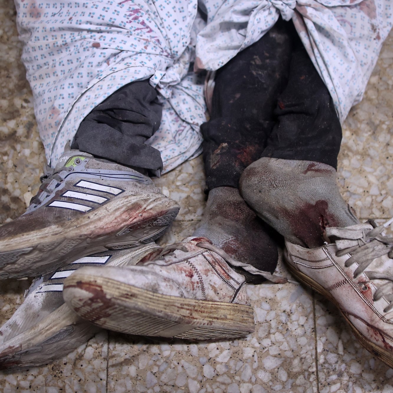 Due paia di scarpe sporche di sangue, avvolte in lenzuola macchiate.