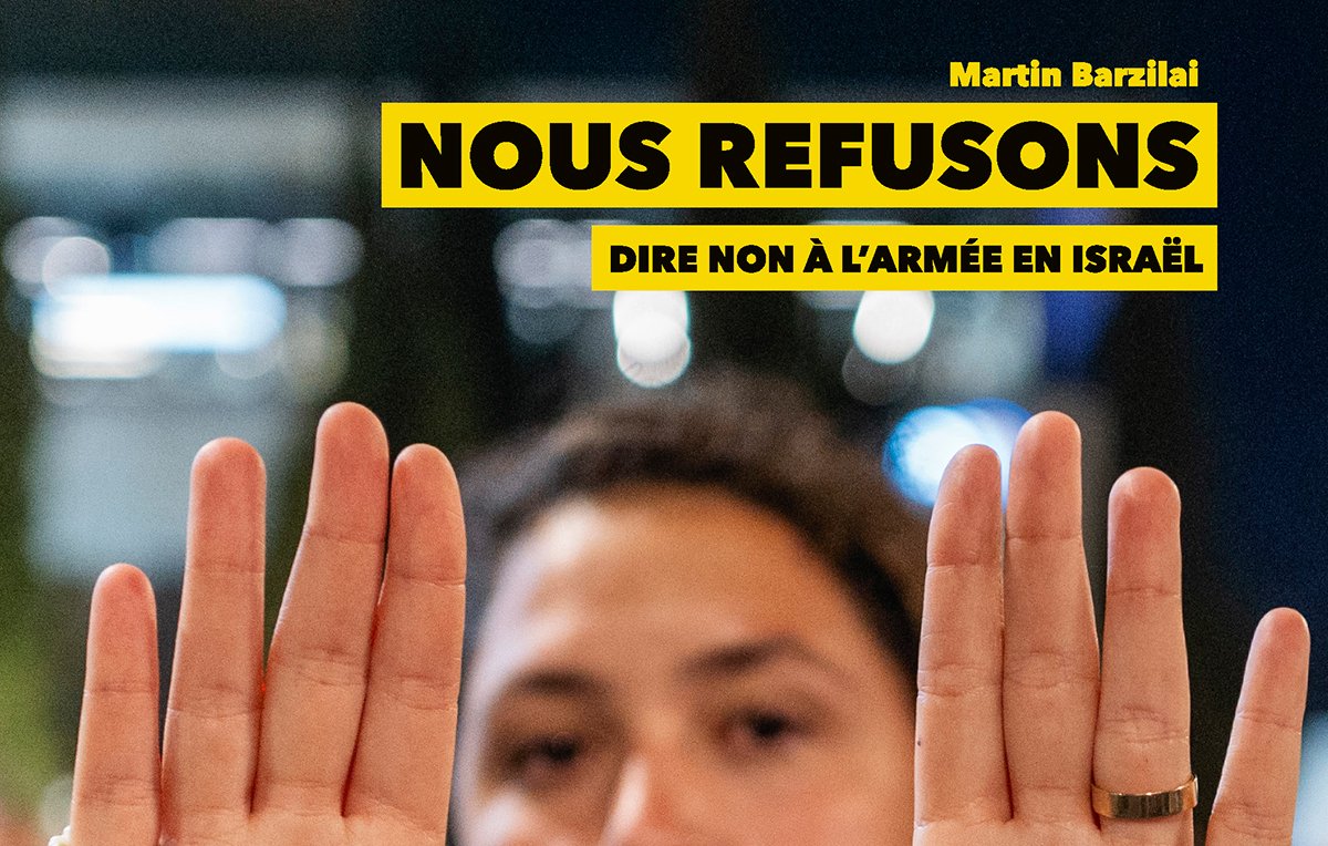 Une personne montre ses mains avec les mots "STOP" et "The WAR" écrits dessus.